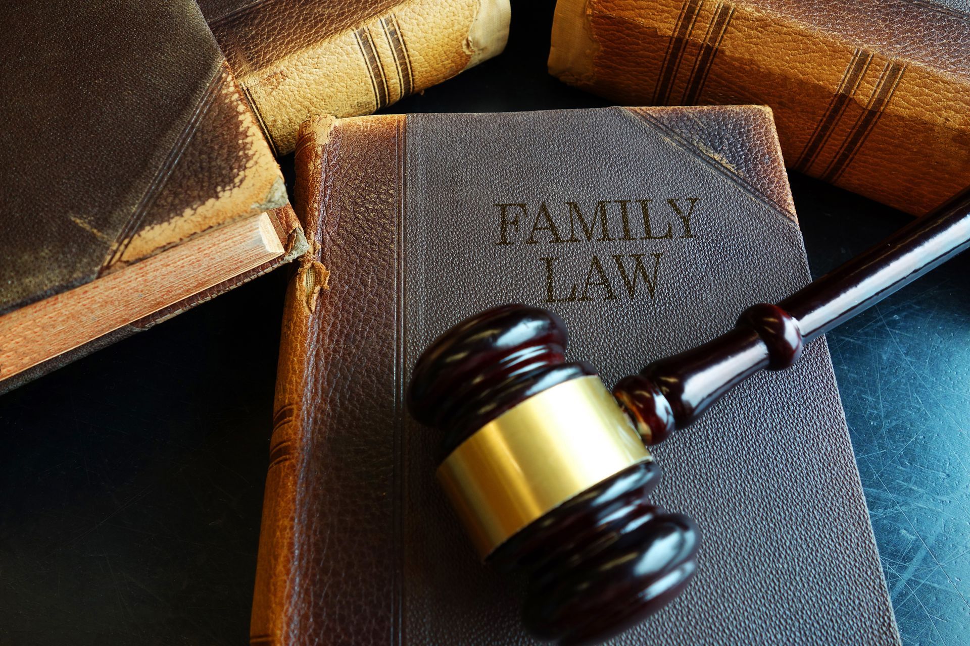 A family law book with a wooden gavel on top of it on the desk of a family lawyer.