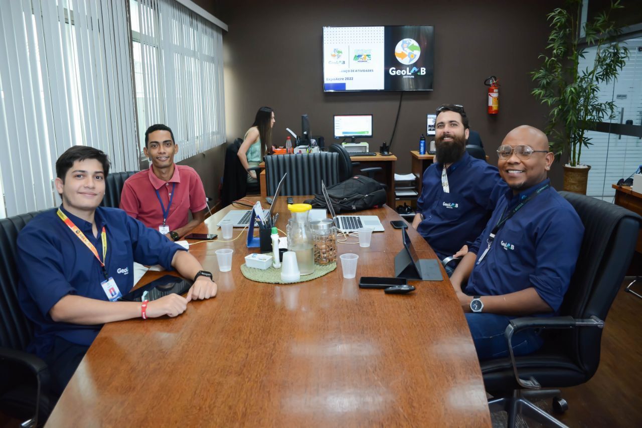 Um grupo de pessoas está sentado à mesa em uma sala de conferências.