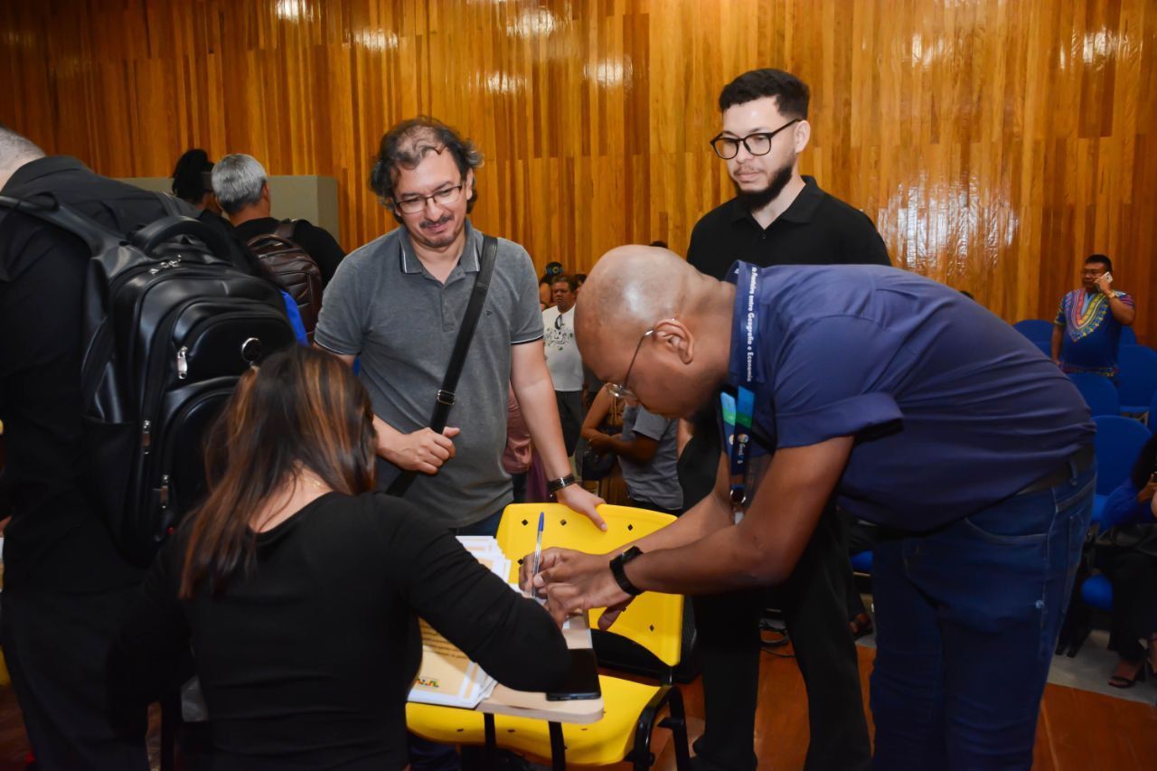 Um grupo de pessoas está em pé ao redor de uma maca amarela.