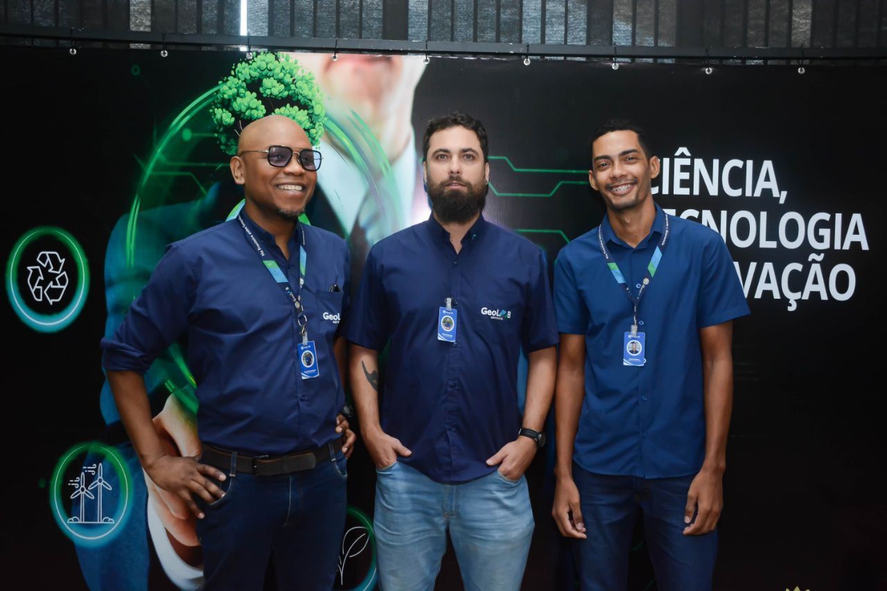 Três homens estão posando para uma foto em frente a uma placa que diz ciência