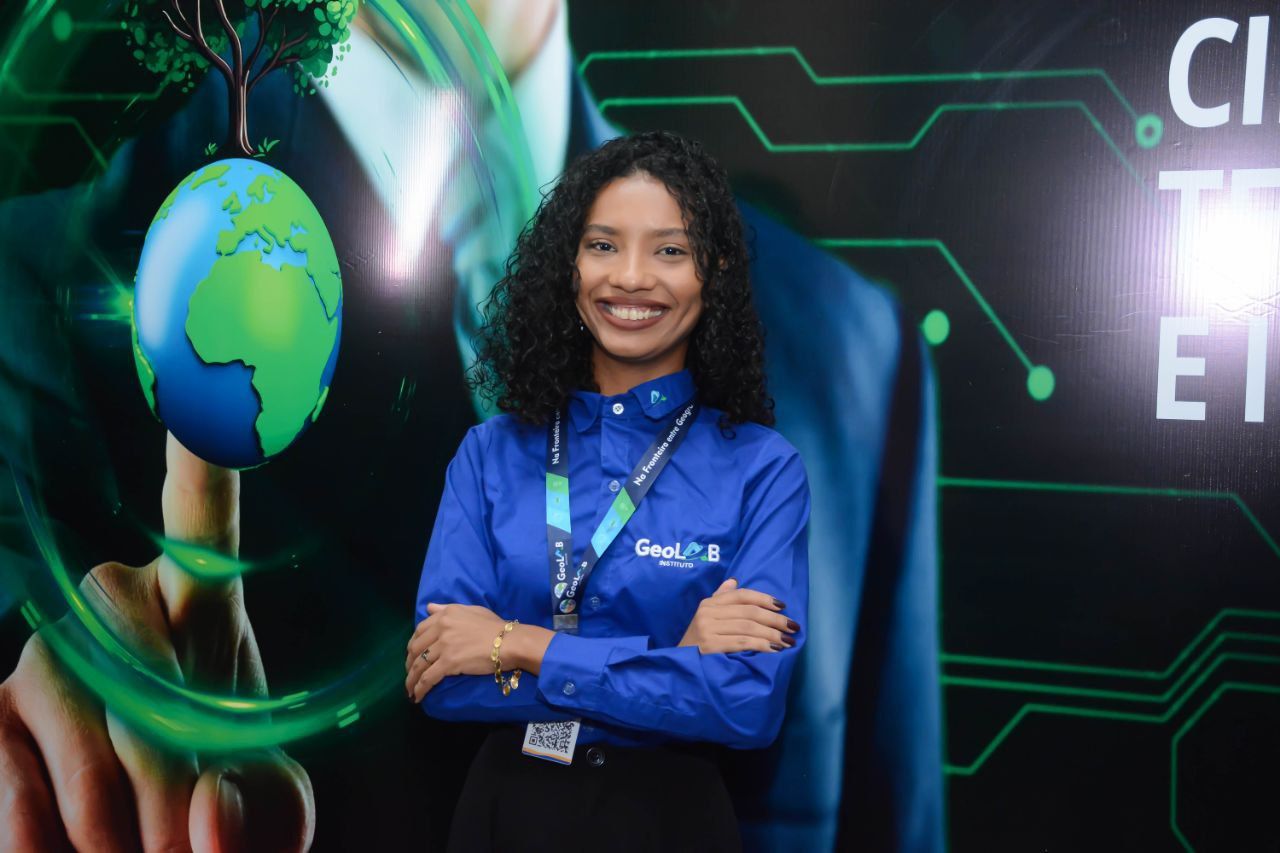 Uma mulher de camisa azul está posando para uma foto com os braços cruzados.