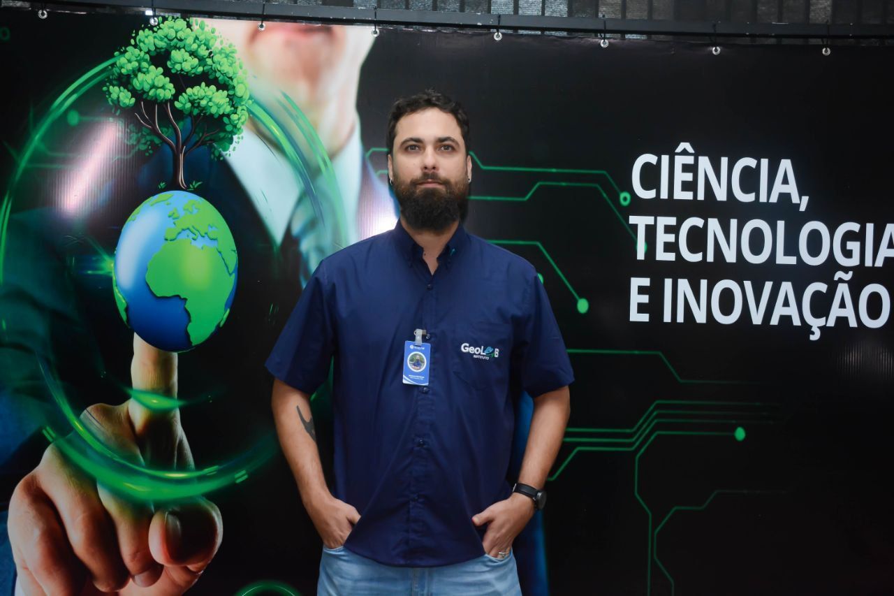 Um homem parado em frente a uma placa que diz ciência tecnologia e inovação