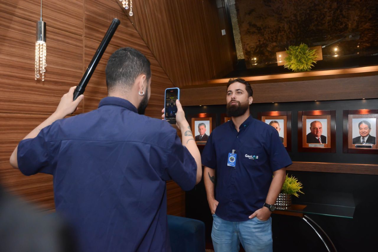 Um homem está tirando uma foto de outro homem com um celular.