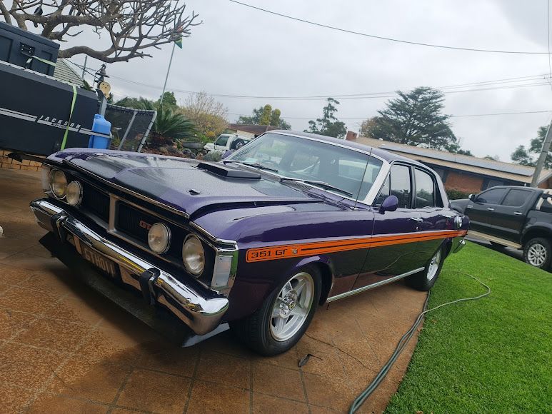 A Purple Car is Parked in a Driveway Next to a House — Roadworthy's On The Run in Harristown, QLD