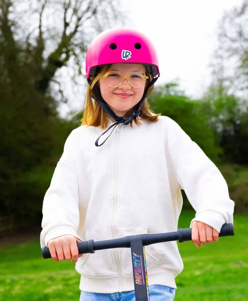 Happy child riding a LIFERYDER kids scooter with parents on a family day out.