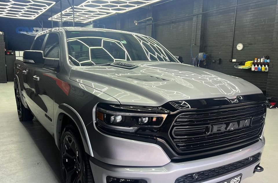 A silver ram 1500 truck is parked in a garage.