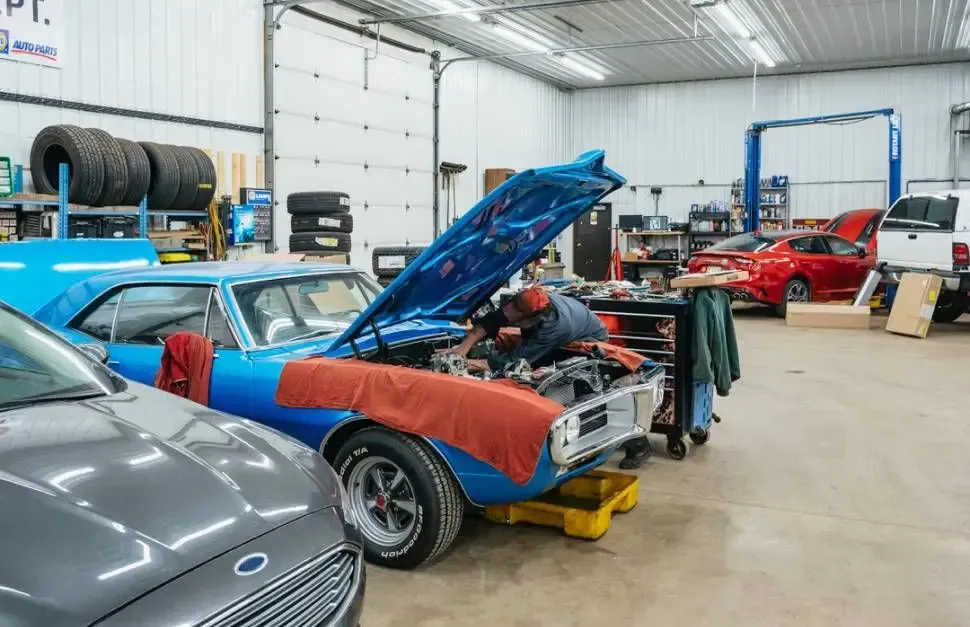 Mechanic working on a blue classic car