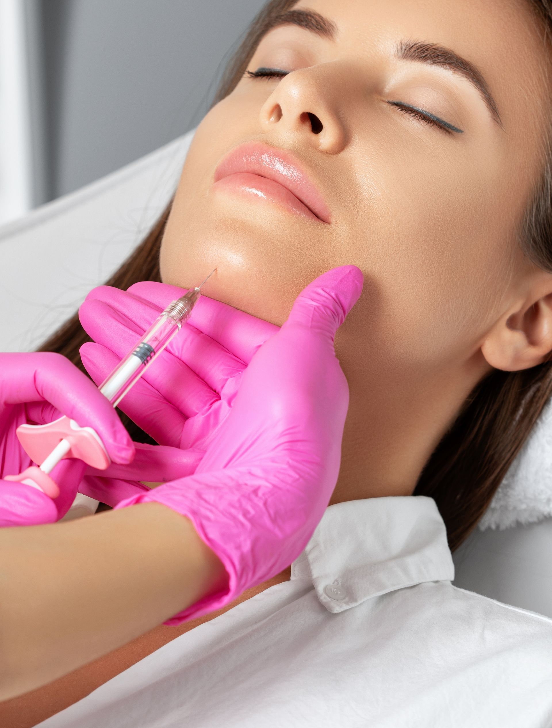 A woman is getting a botox injection in her face.