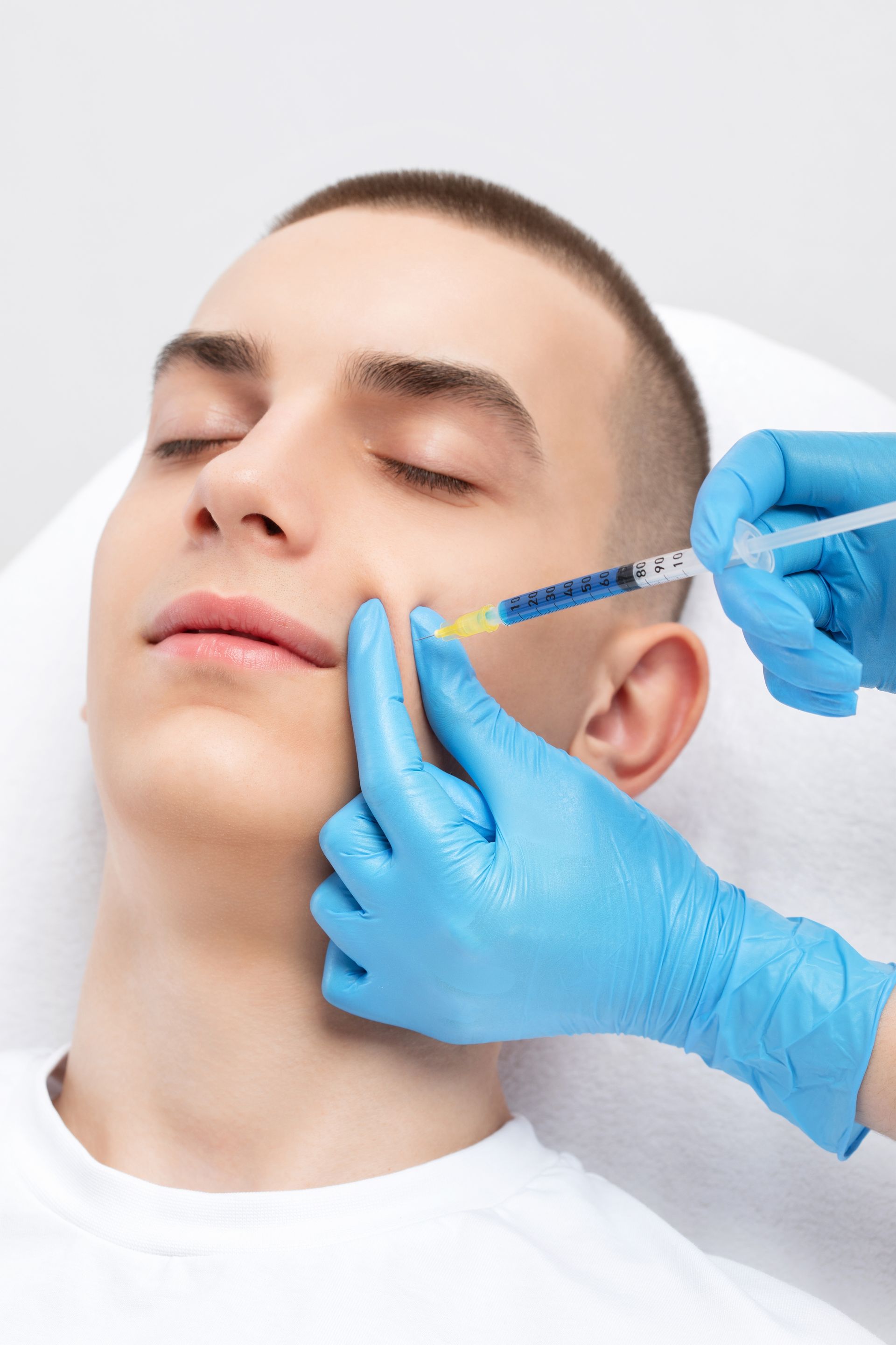 A man is getting a botox injection in his face.