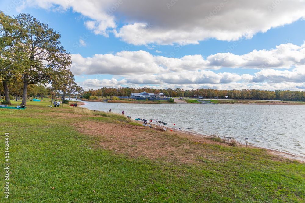 A large body of water surrounded by trees and grass on a sunny day.