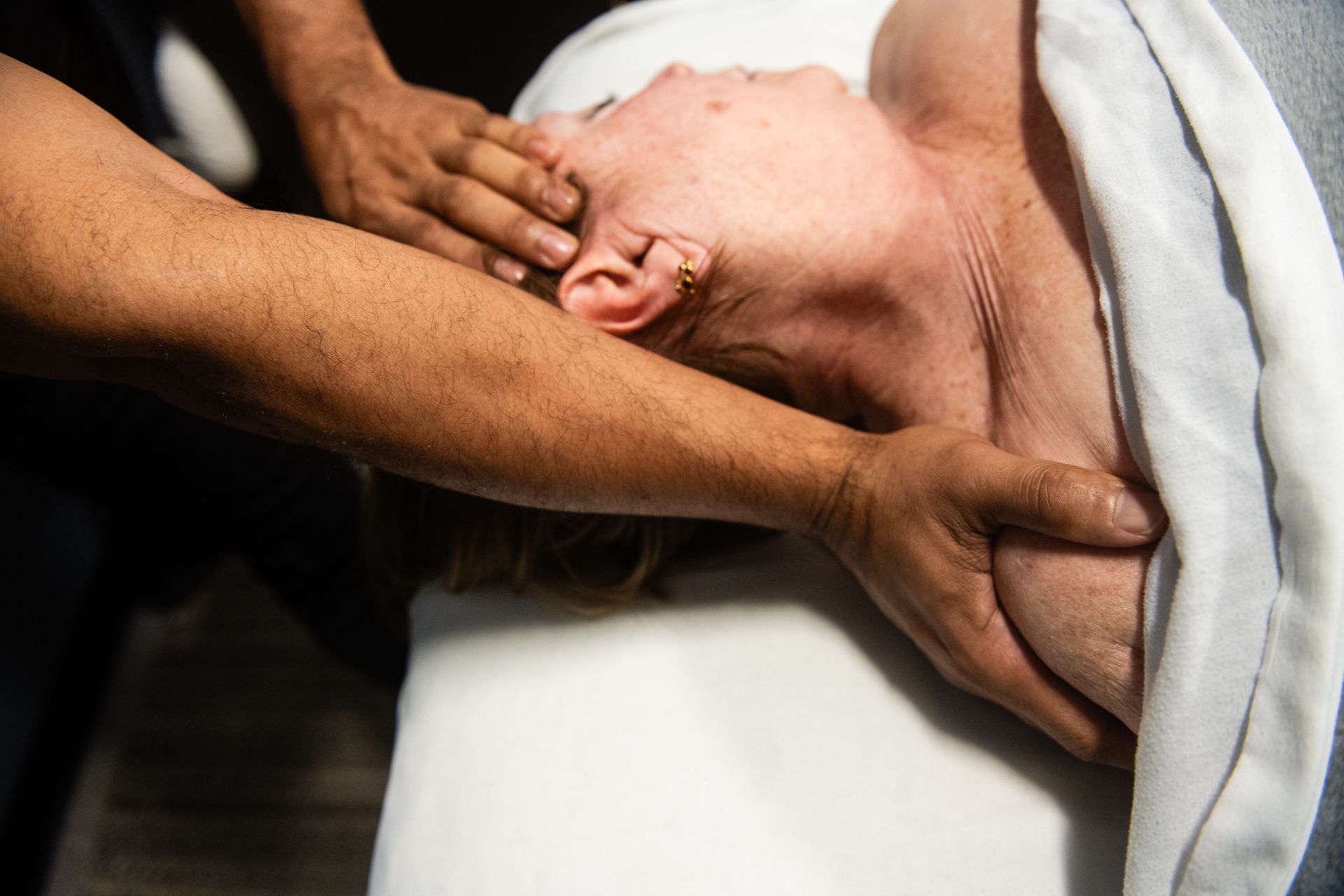 A person's arm being examined by a medical professional in a clinic setting.
