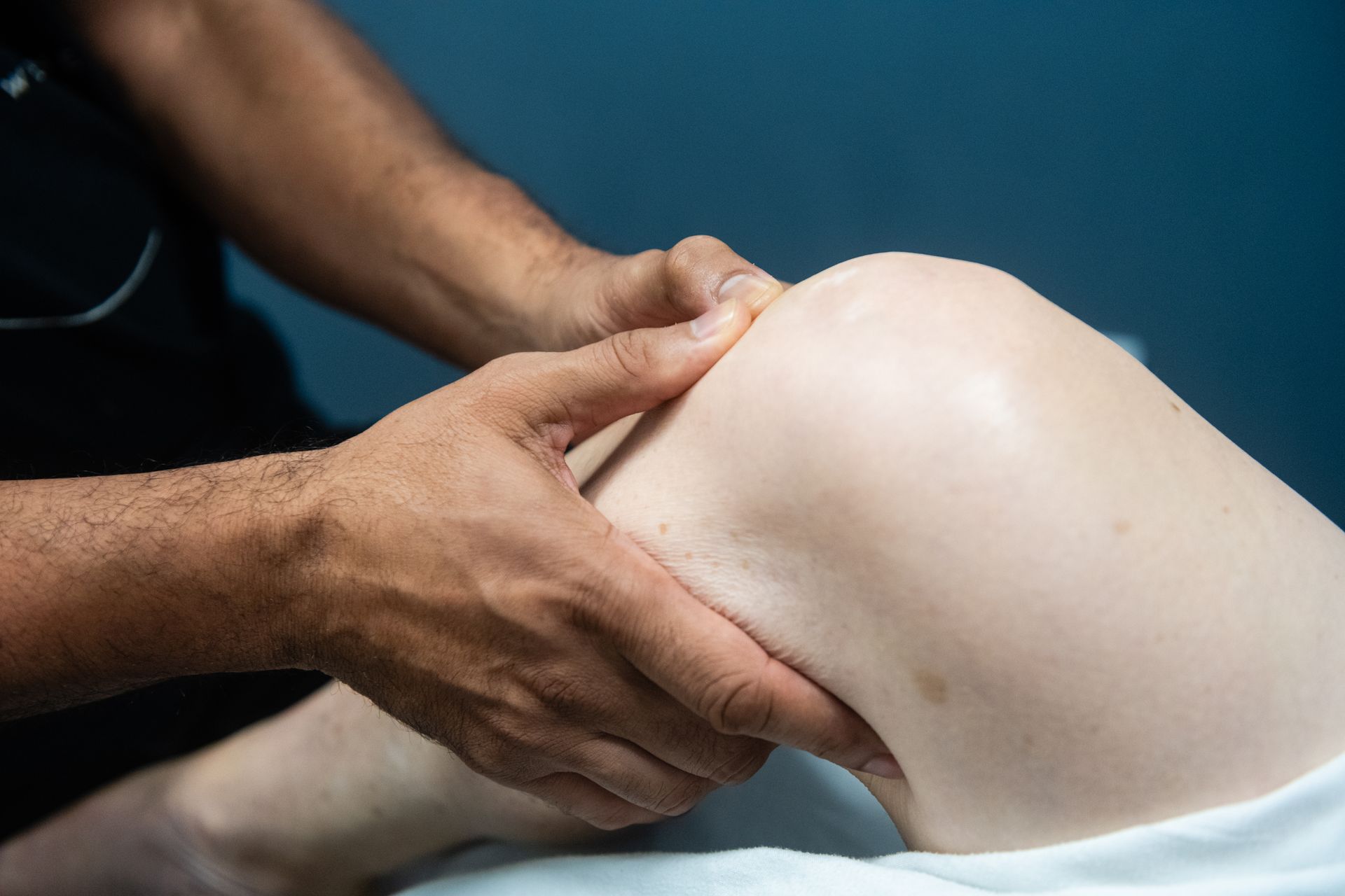 A person is holding their knee in pain.