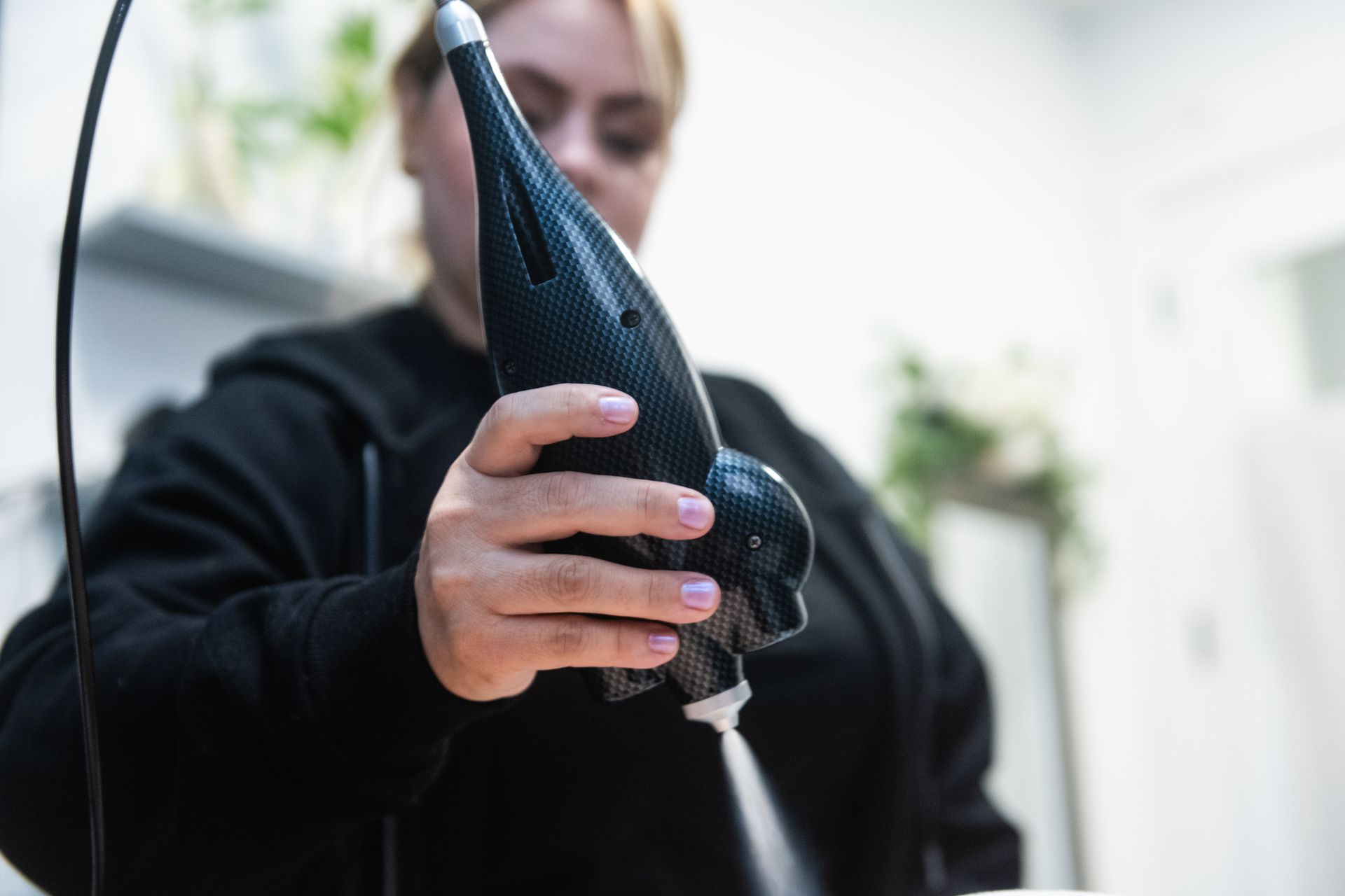 Woman receiving blue light therapy on her knee, lying on a medical table, indoors.