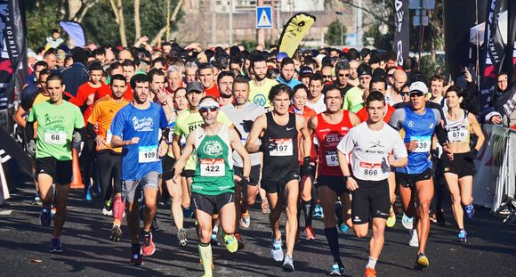 A group of people are running a marathon on a city street.