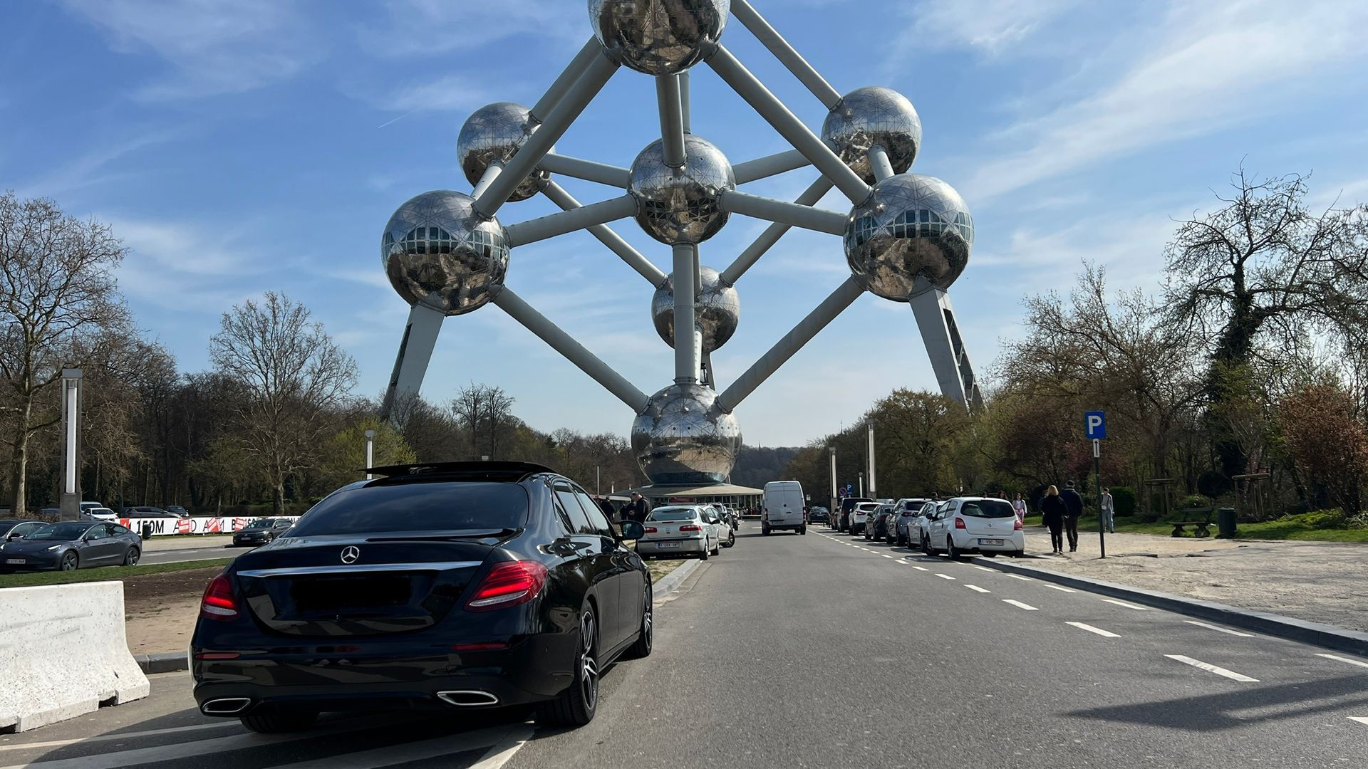 Een auto staat geparkeerd aan de kant van de weg voor een reuzenrad