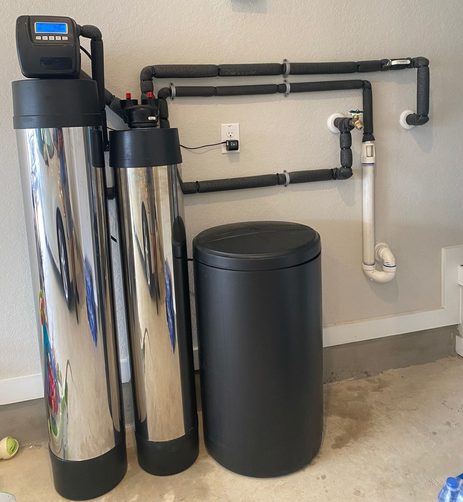 Two stainless steel water filters are sitting next to each other in a room.