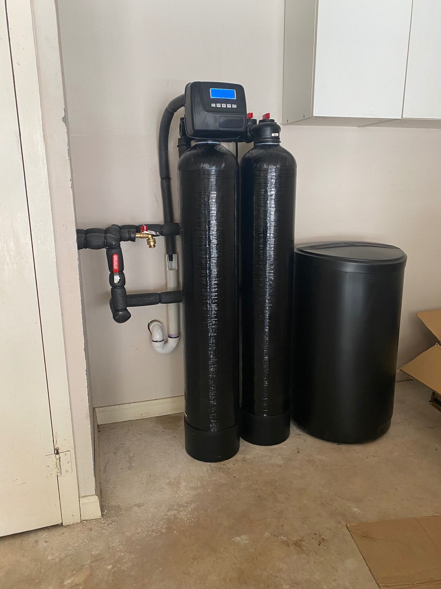 Two black cylinders are sitting next to each other in a room.