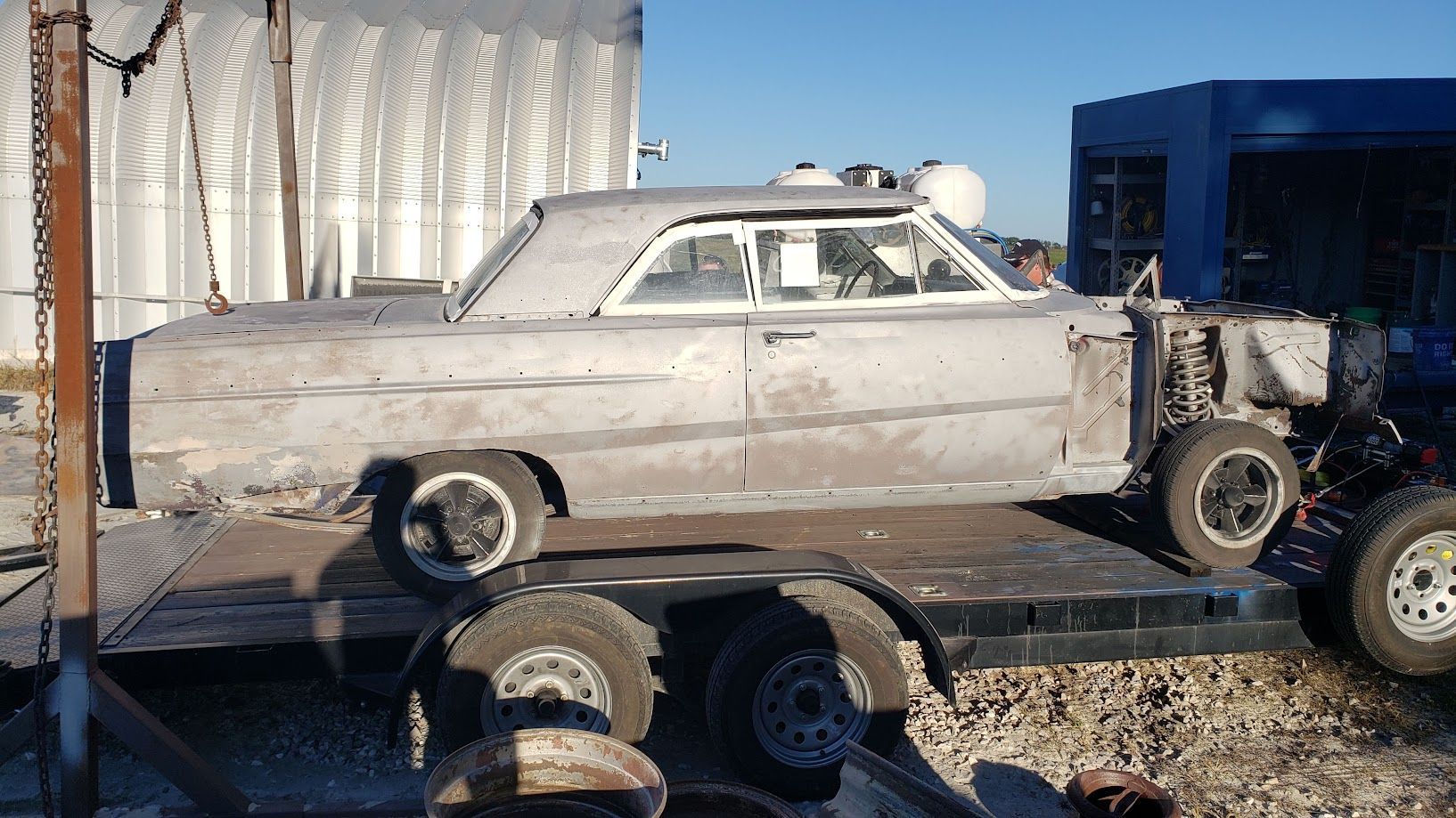 An old car is sitting on top of a trailer.