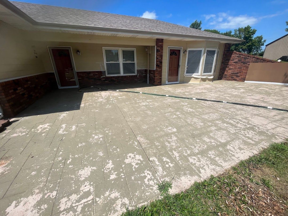 A house with a concrete driveway in front of it.