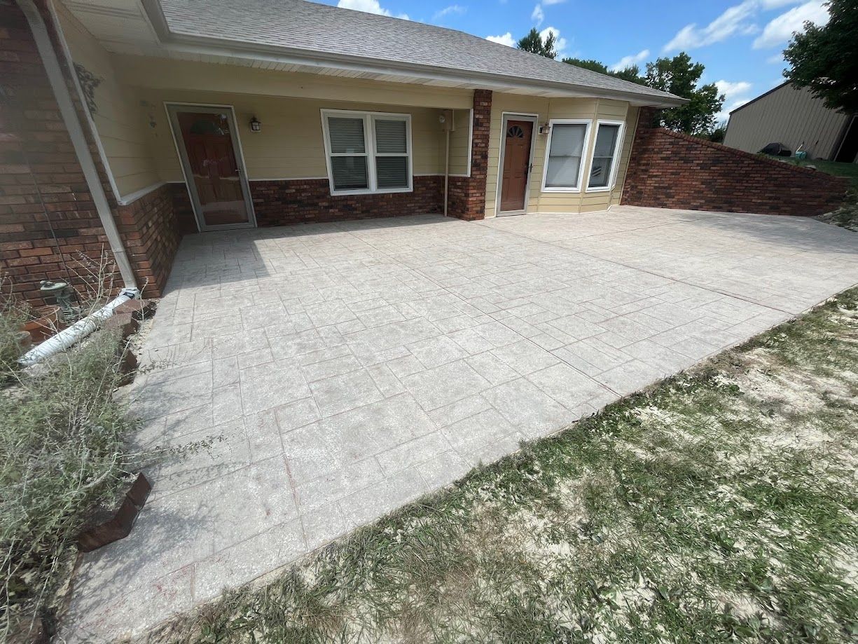 A house with a concrete driveway in front of it.