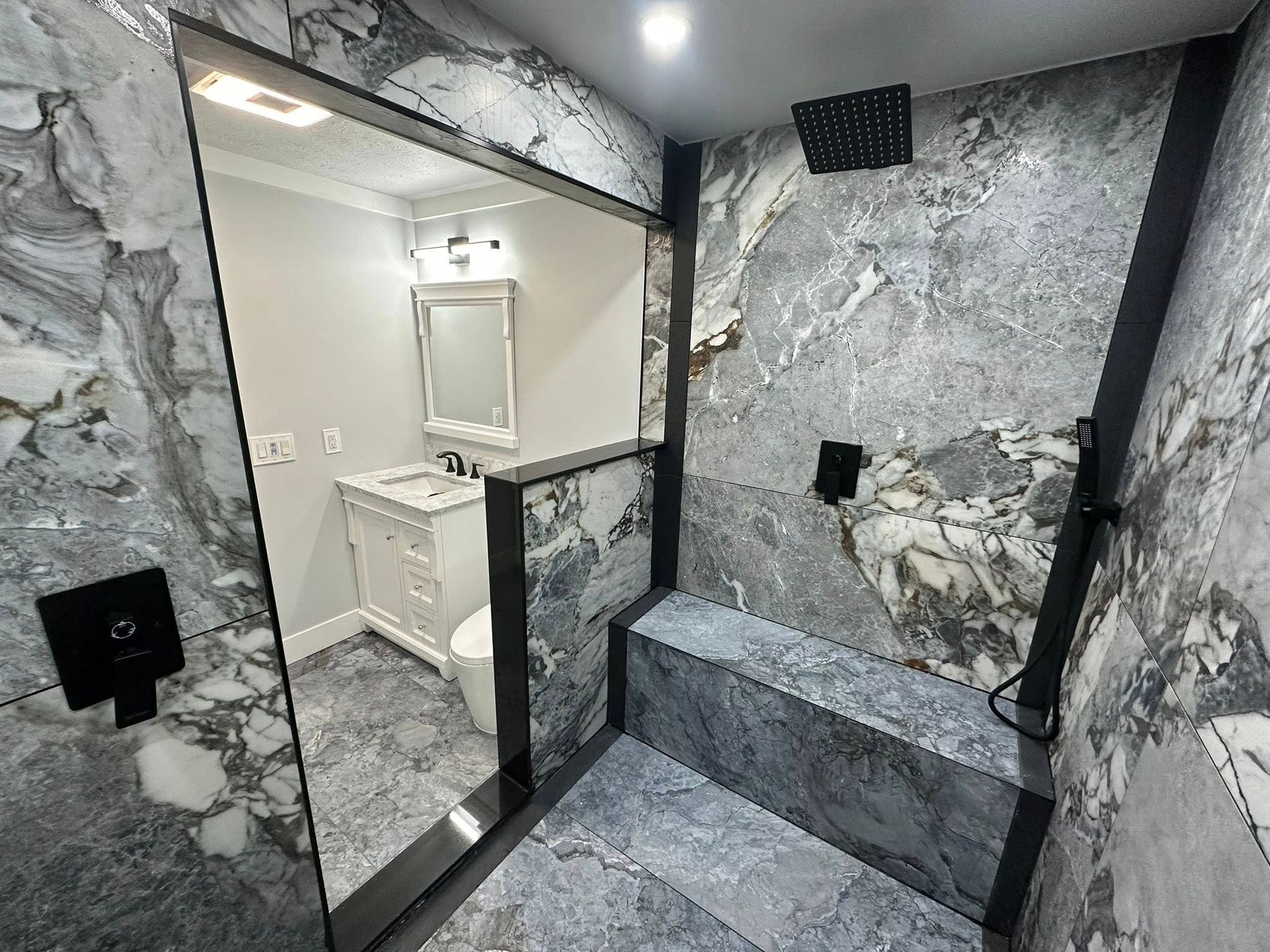 Bathroom with toilet, shower, and vanity. Beige walls, white fixtures, and a closed door.