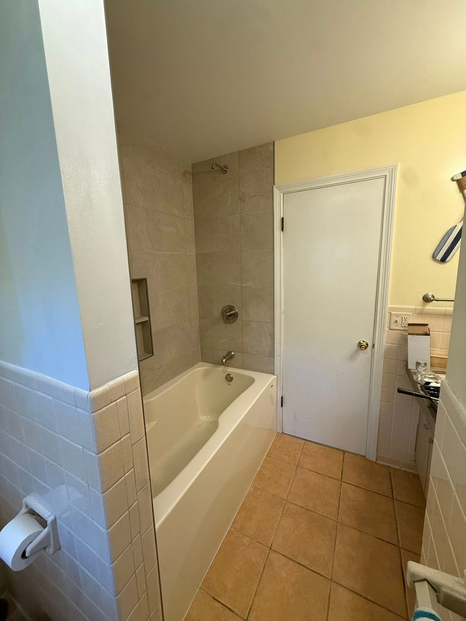 Bathroom with a bathtub, showerhead, toilet, and tile floor.