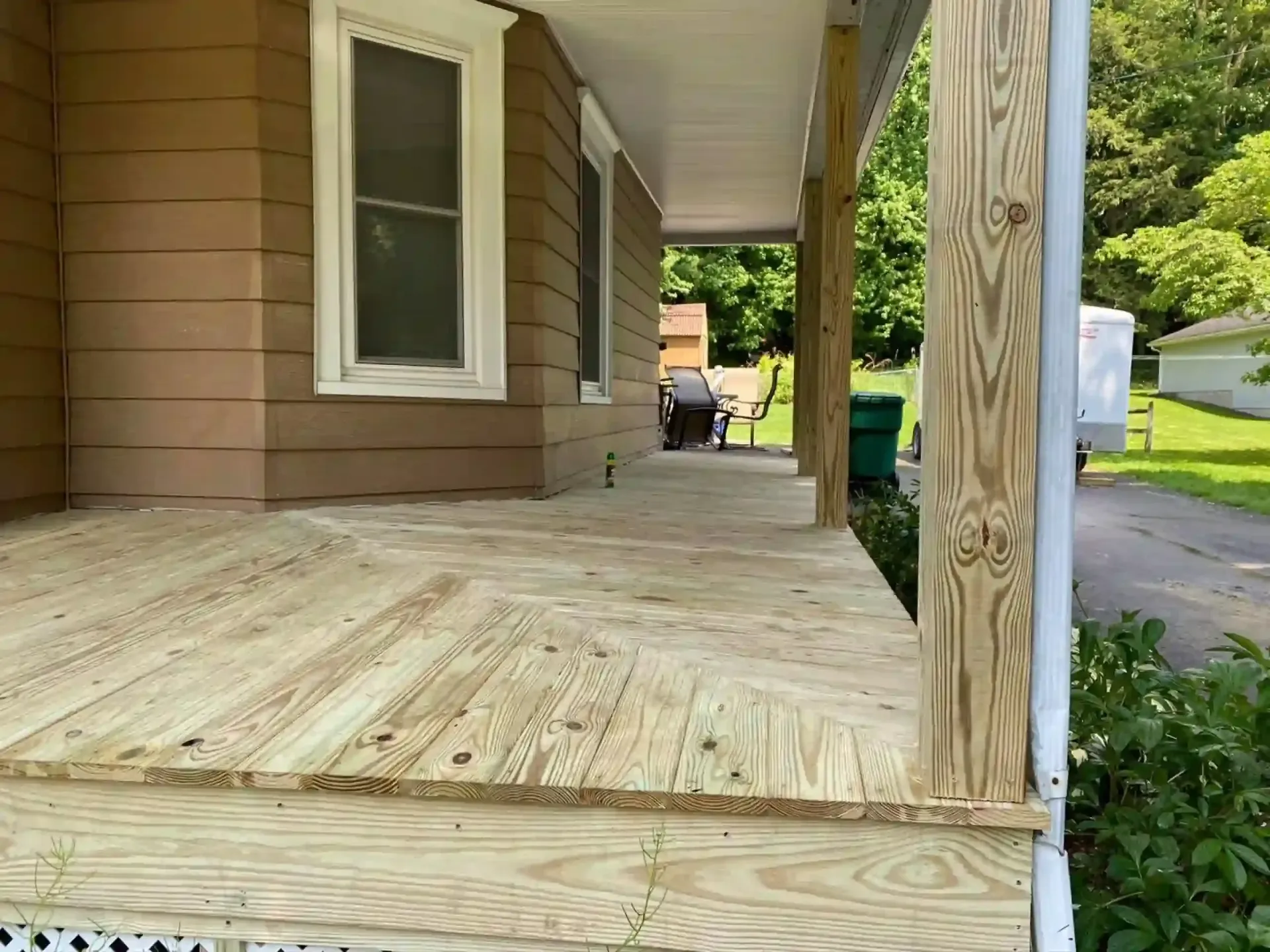 Wooden porch of a house, with a newly built deck.