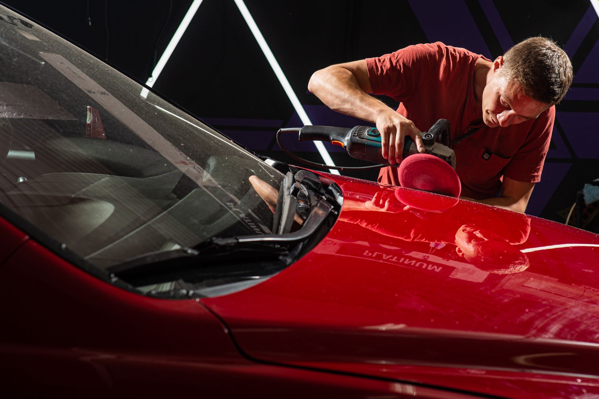 A Man Is Polishing the Hood of A Red Car - Parma, OH - Family First Car Care