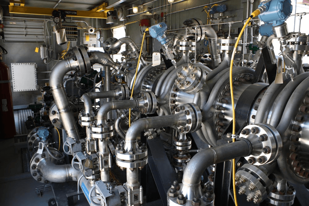 A bunch of pipes are connected to a machine in a factory.