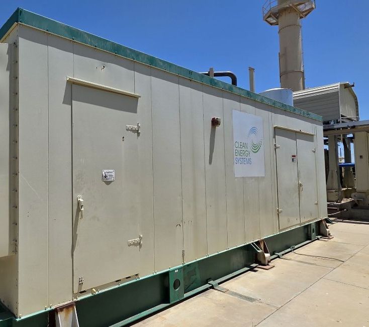 A man is standing next to a clean energy systems direct steam gas generator