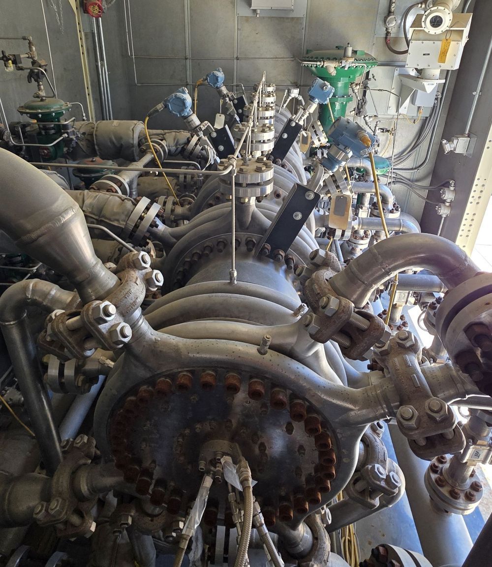A machine with a lot of pipes attached to it on a white background.