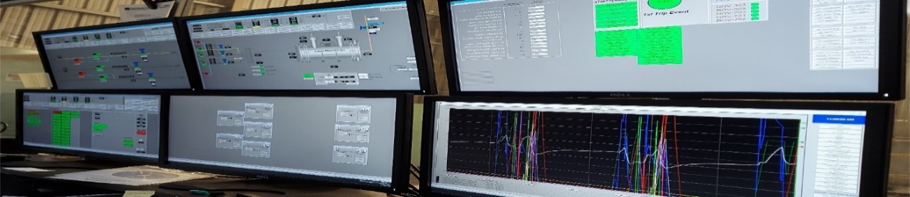 A row of computer monitors sitting next to each other in a room.