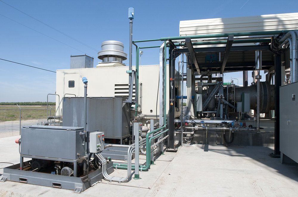 A large industrial building with a lot of pipes coming out of it