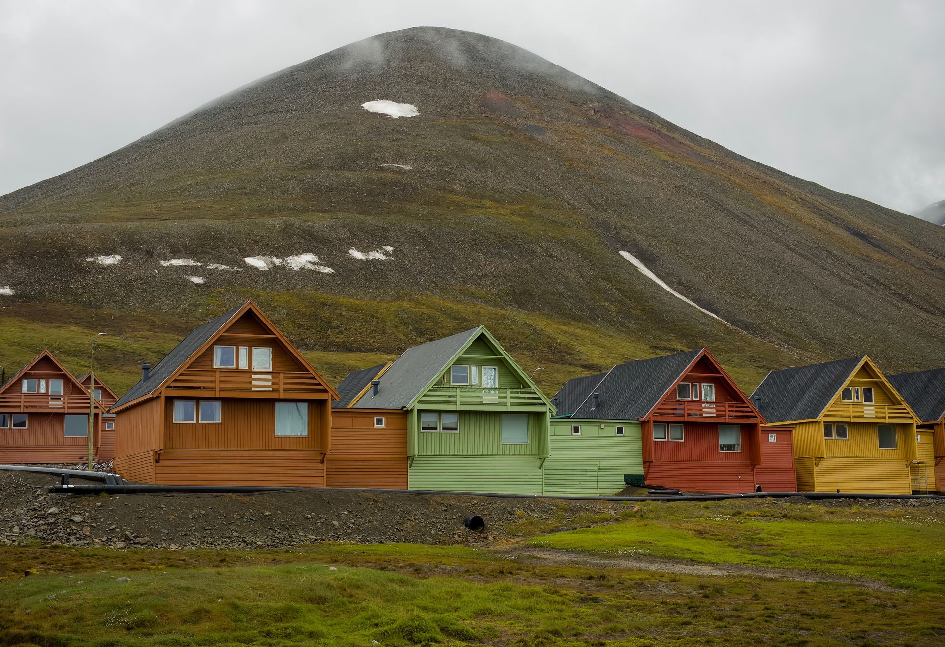 A row of colorful houses in front of a mountain