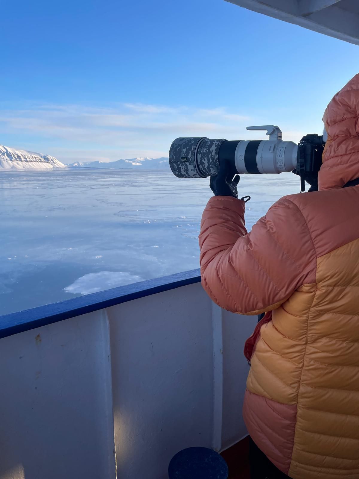 A person is taking a picture of a body of water with a camera.