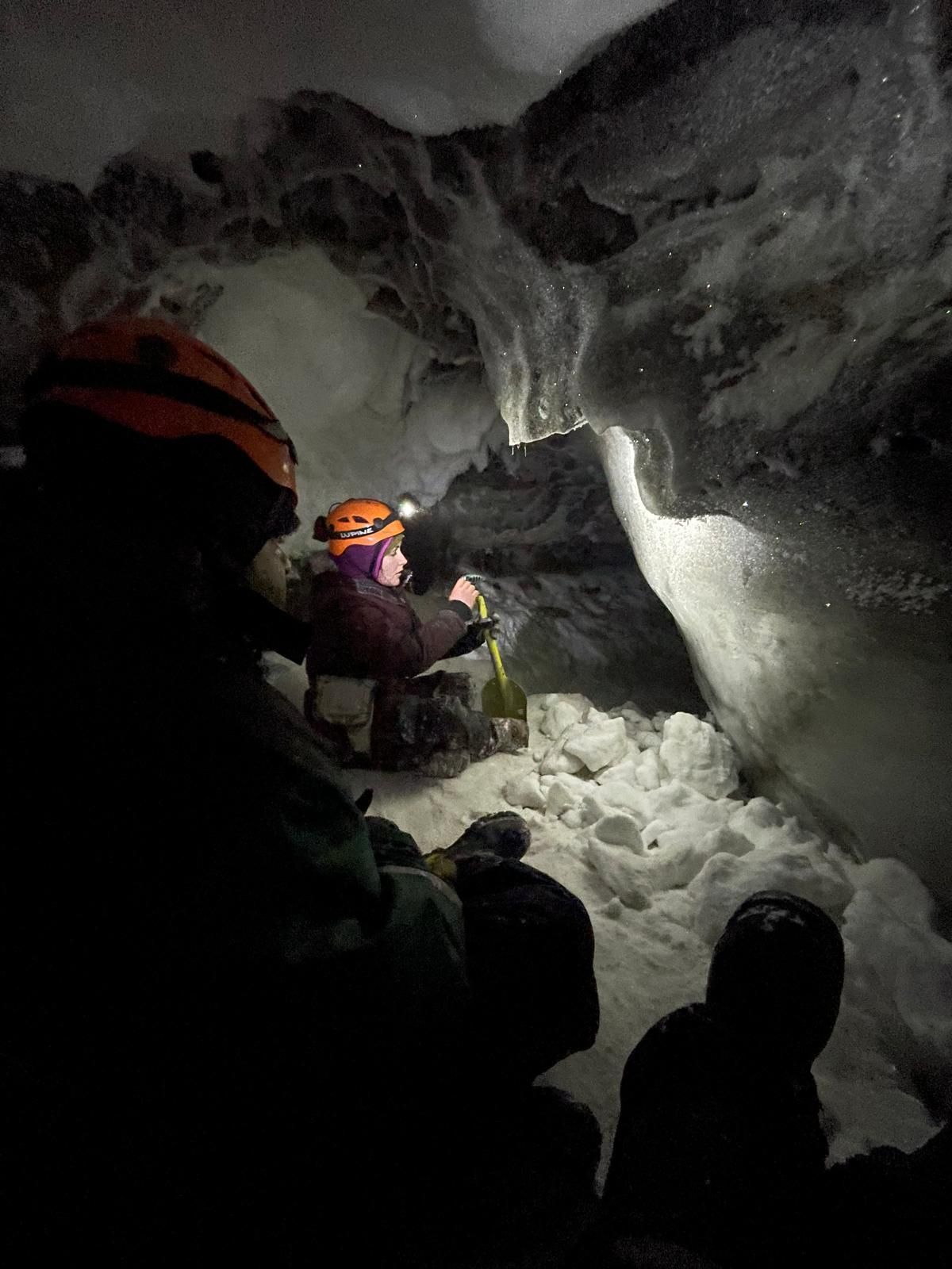 A cave filled with ice and snow with icicles hanging from the ceiling.