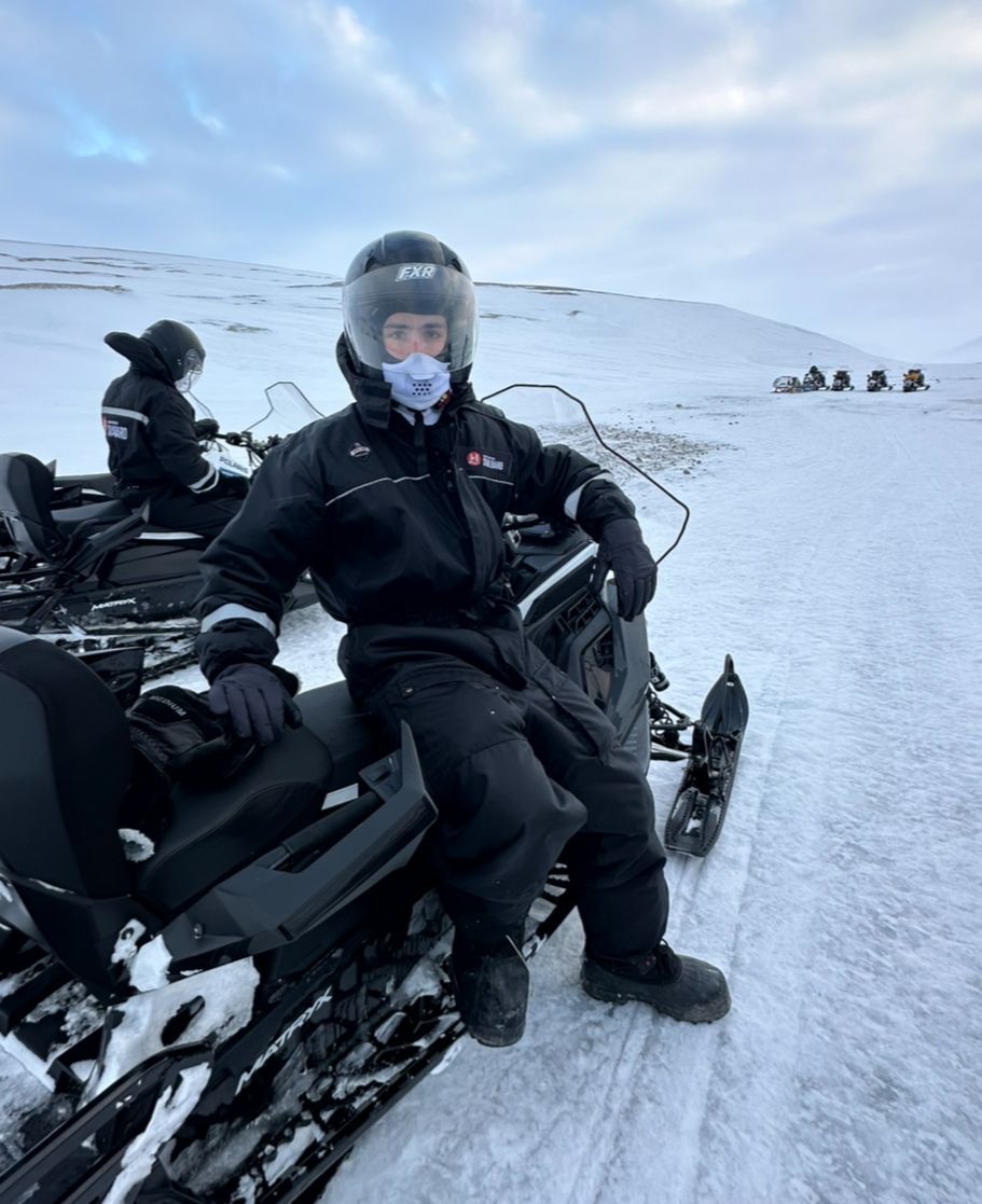 A man is standing in front of a helicopter on a runway.