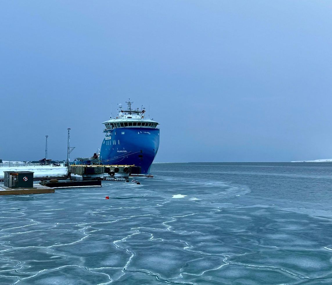 A boat is floating on top of a body of water with mountains in the background.