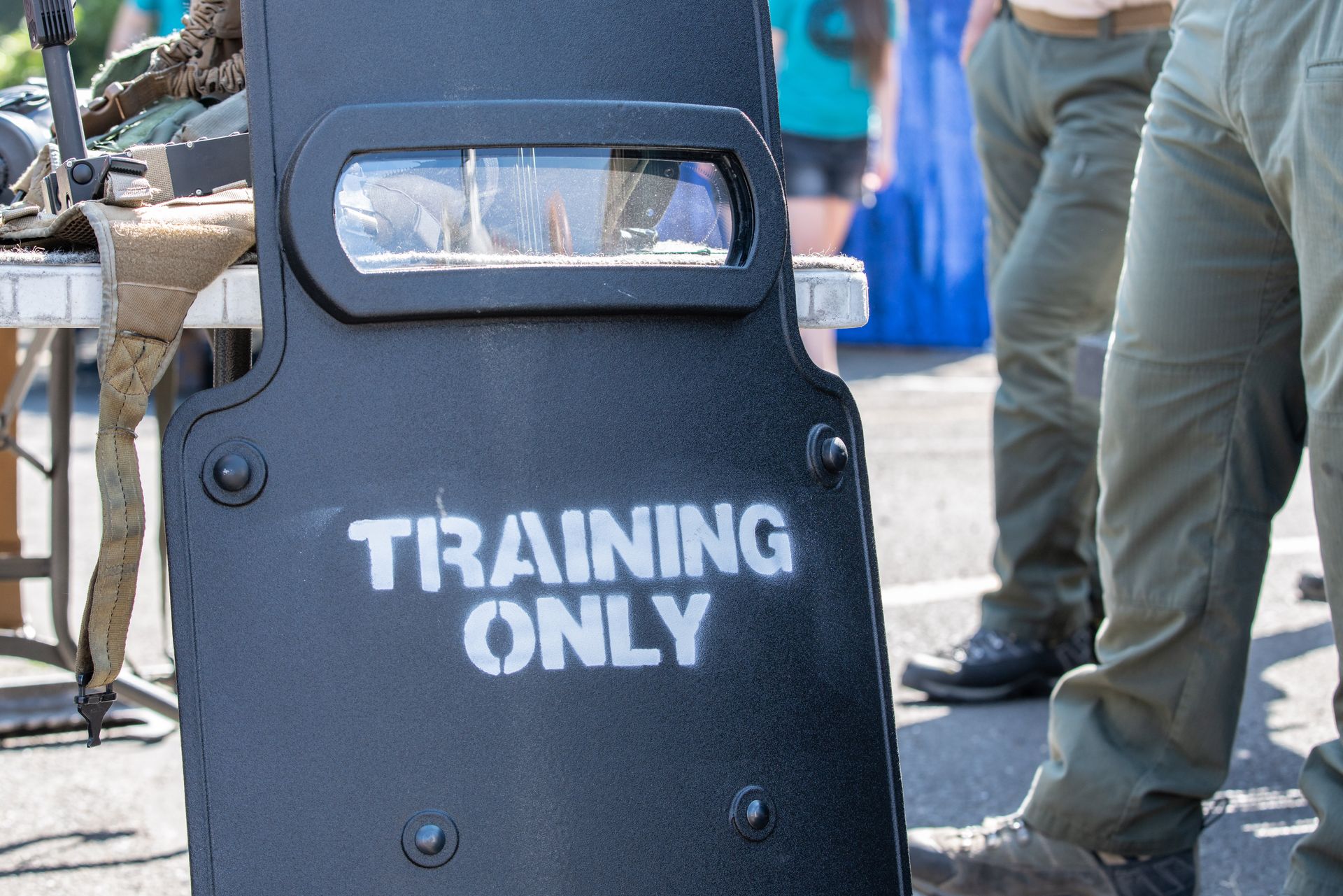 A training shield labeled ‘Training Only’ standing beside gear during a law enforcement drill.