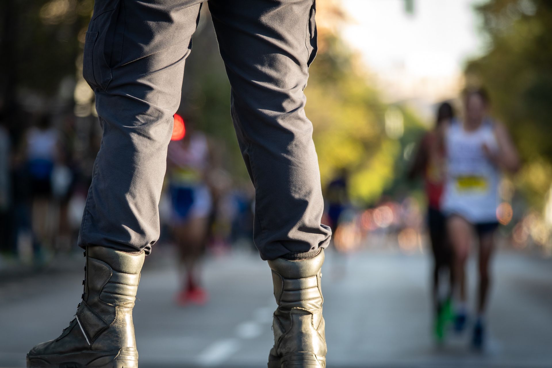 A partial bottom view of a member of a security team guarding a street for a running event.