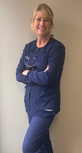 Family smiles for a photo; two boys, a woman in floral, and two people in caps. Inside a building.