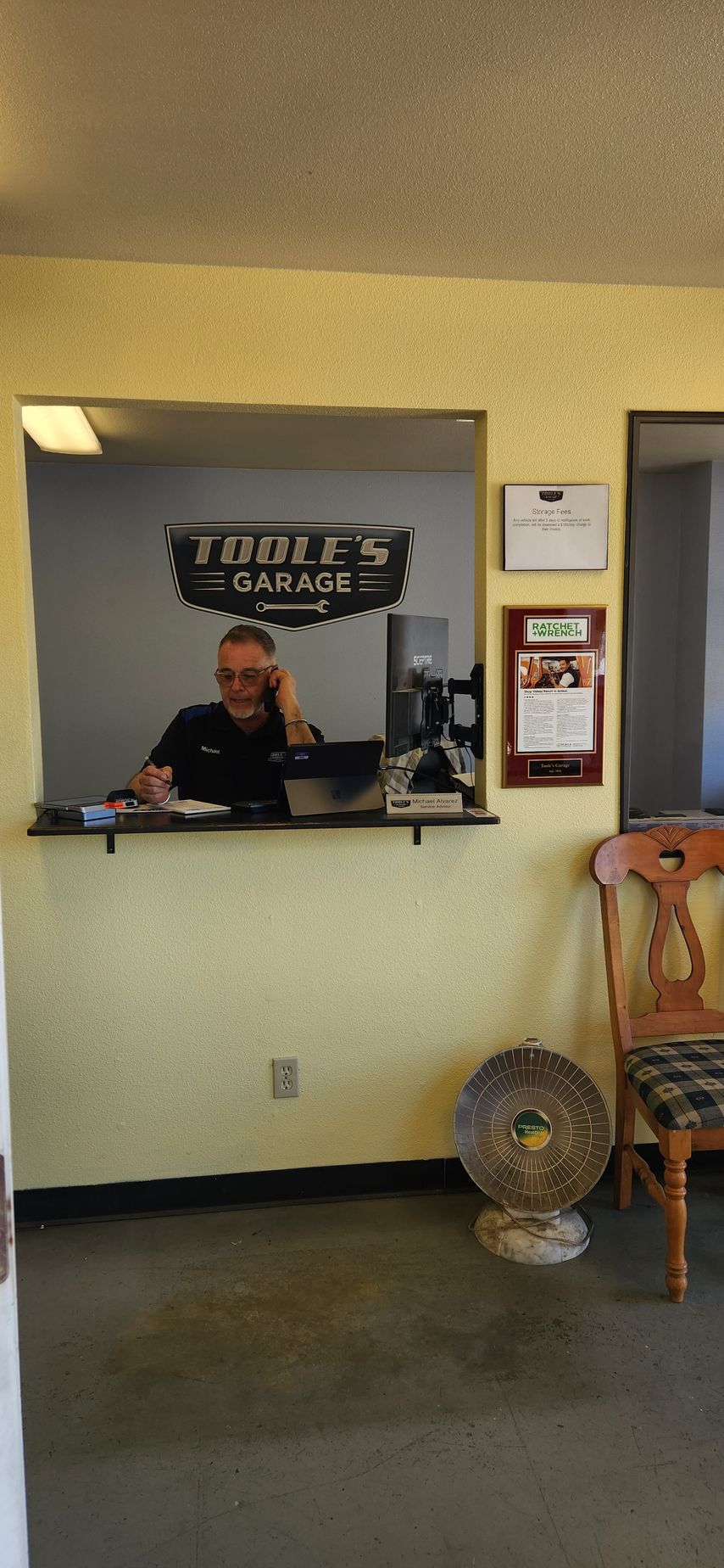 A man is sitting at a counter in a waiting room.