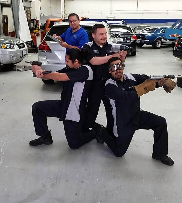 A group of men are posing for a picture in a garage