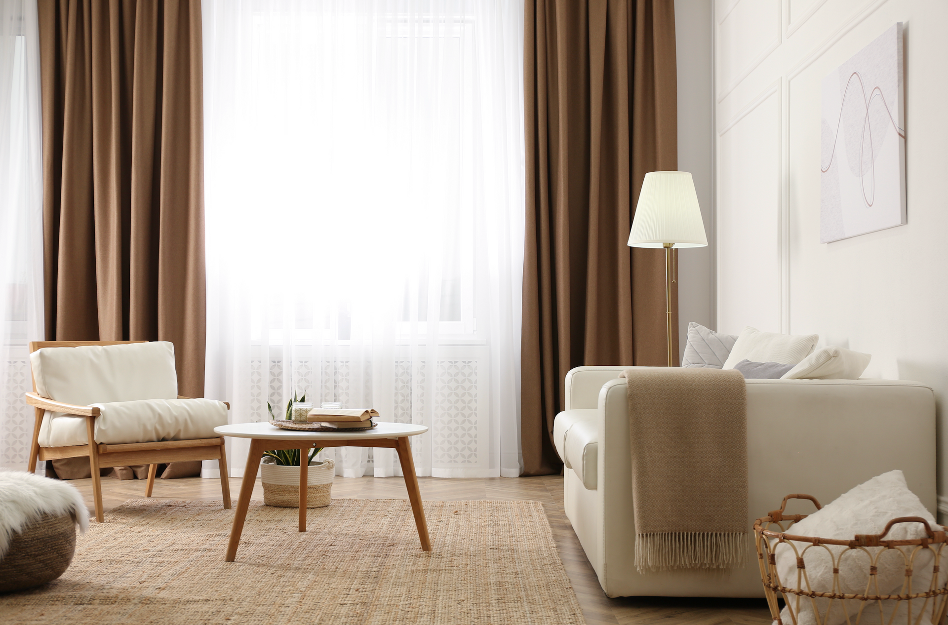 A living room with a couch , chair , table and lamp.