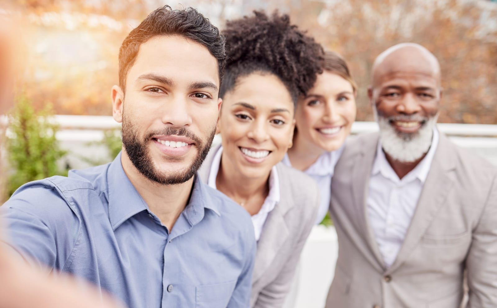 A group of happy business people are taking a selfie together.