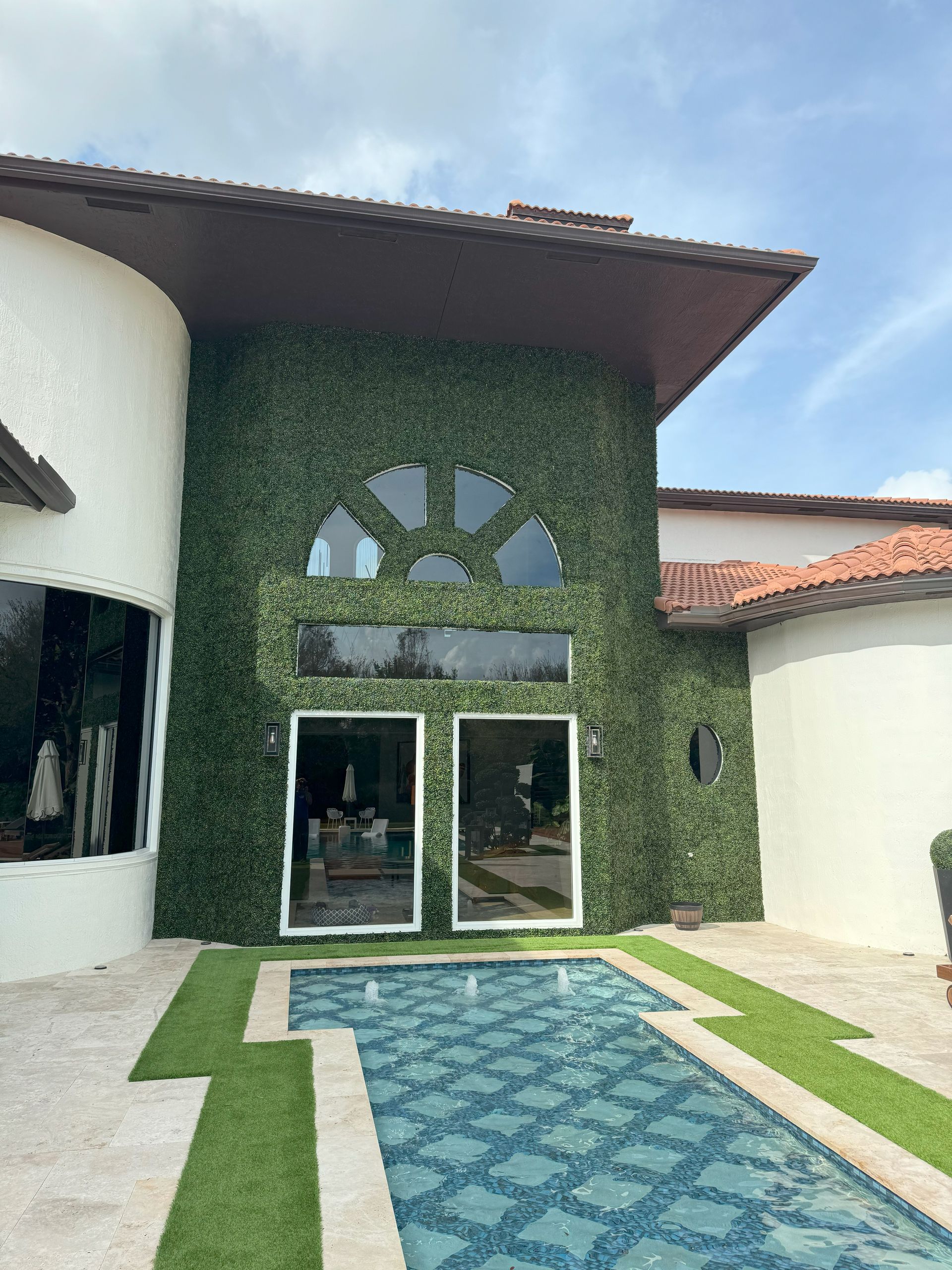A large house with a swimming pool in front of it.