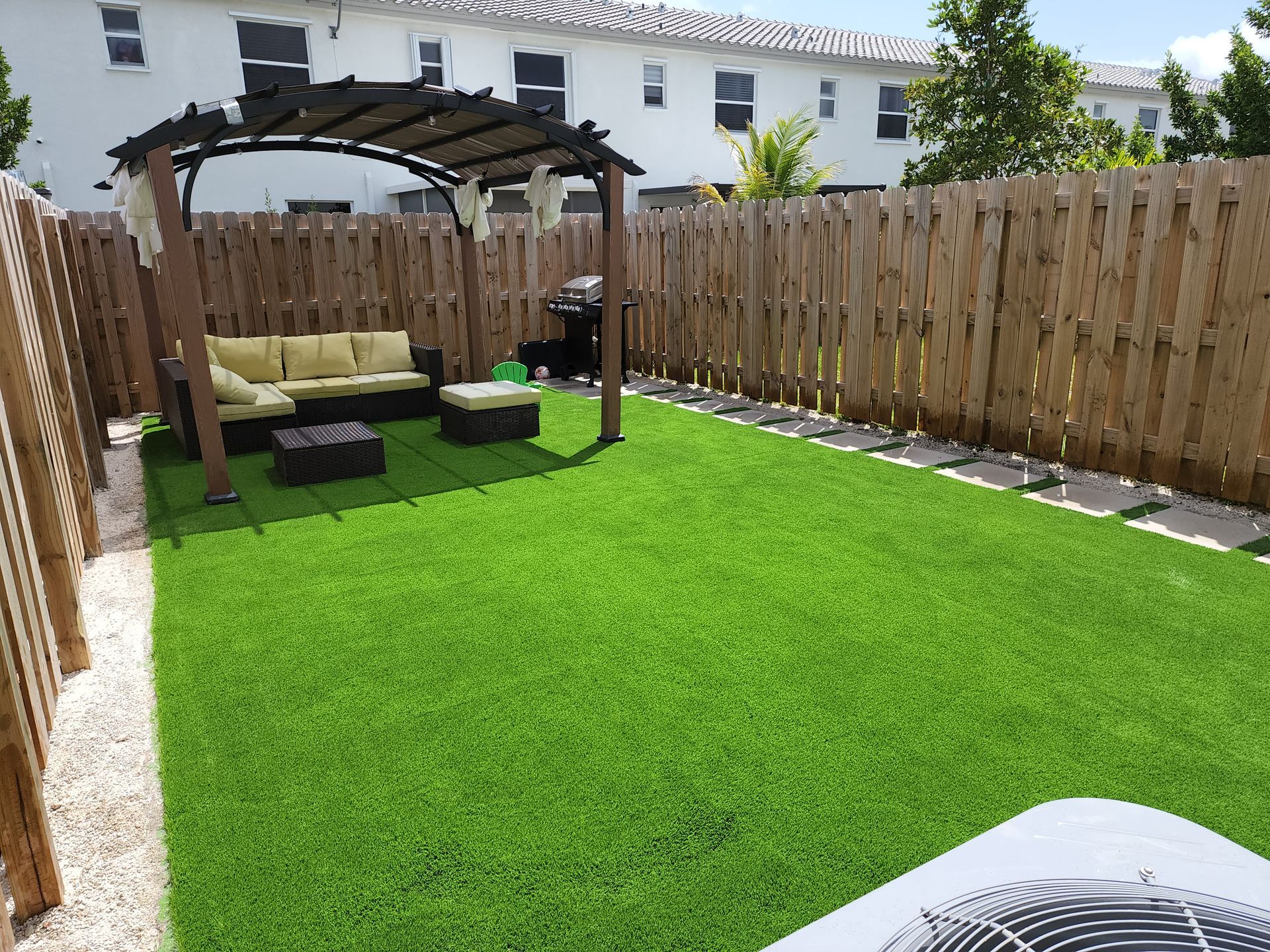 A backyard with a pergola and a couch in it