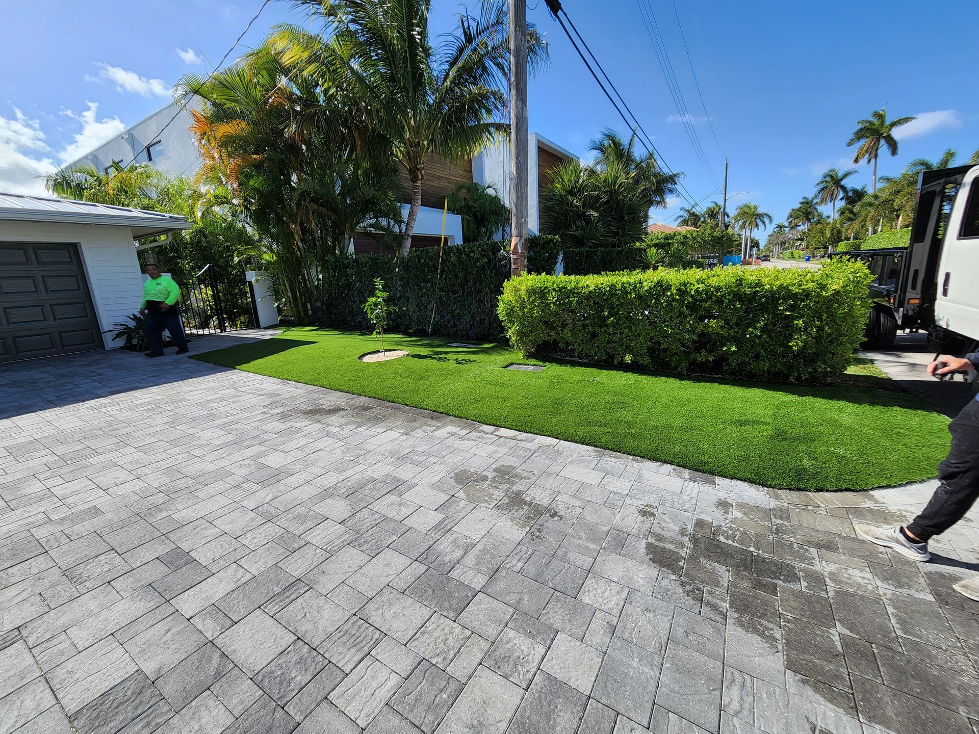 A man is walking down a brick driveway next to a truck.