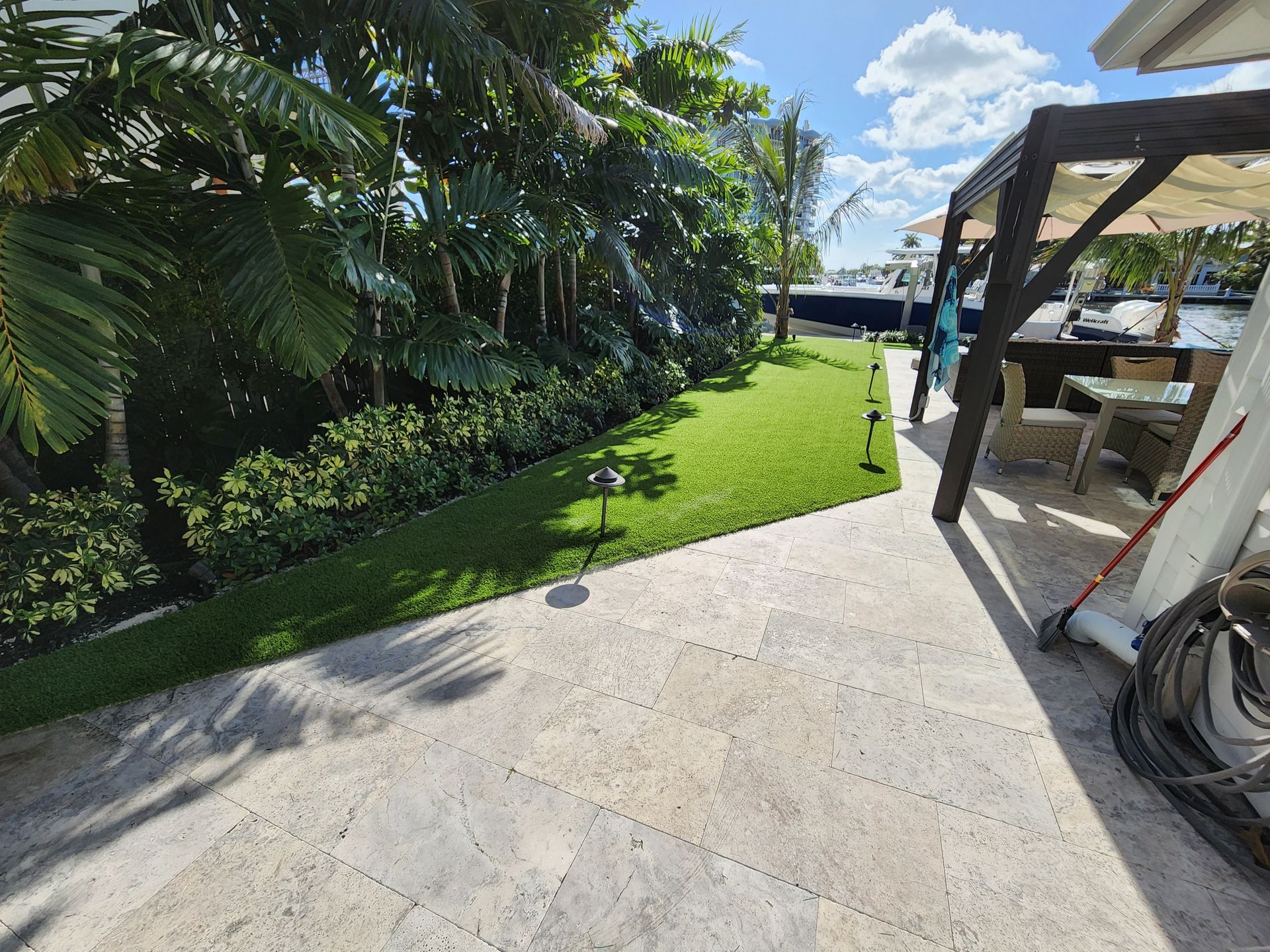 A patio with a table and chairs in the backyard of a house.