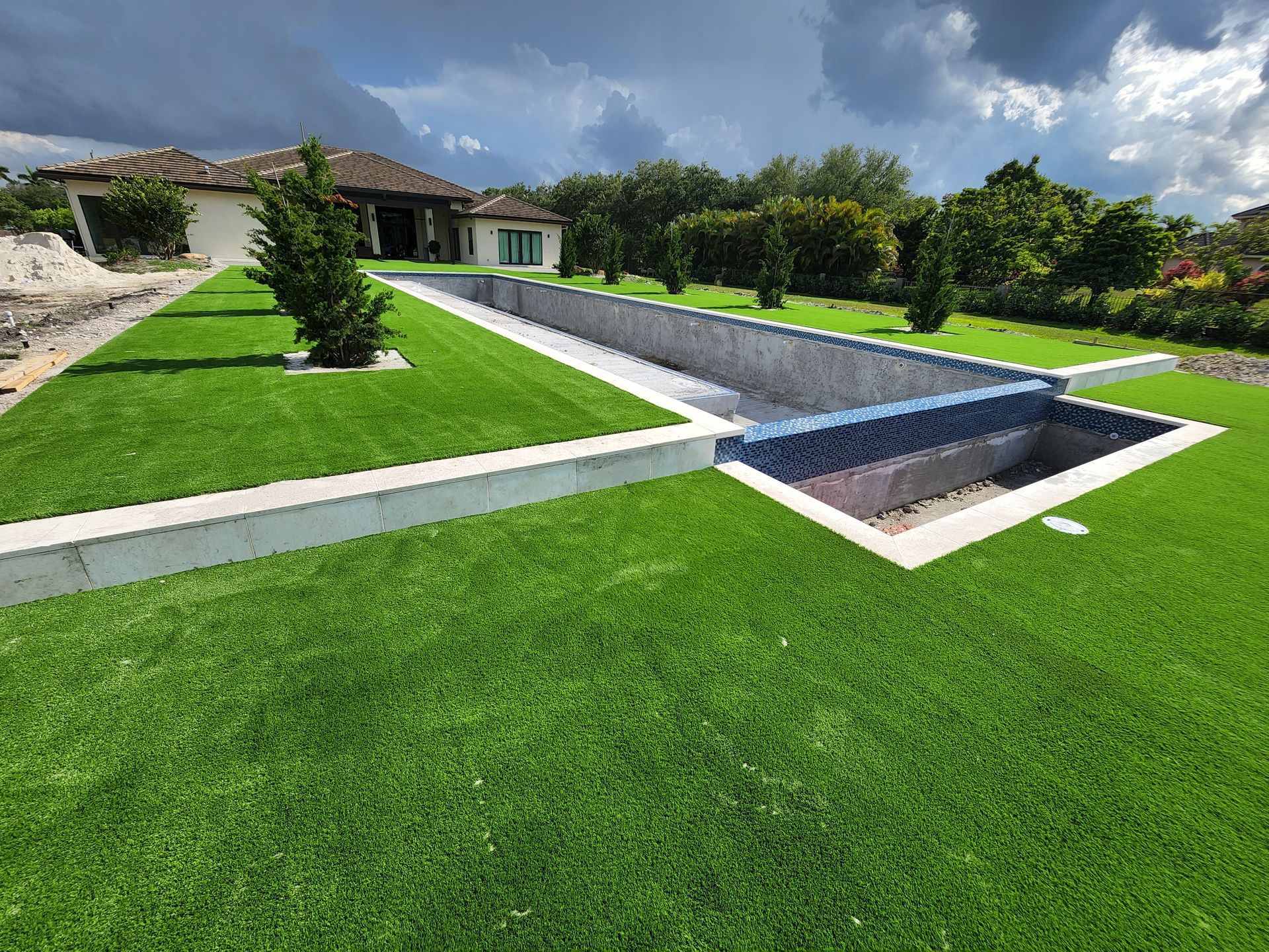 There is a large swimming pool in the backyard of a house.